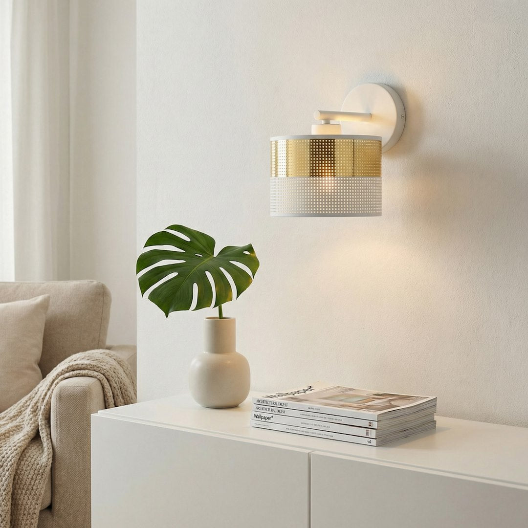 Mise en ambiance de l'applique murale allumée au-dessus d'un meuble blanc avec plante et magazines.