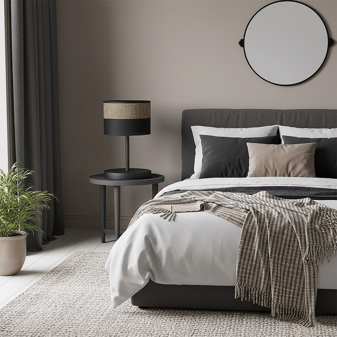 Mise en ambiance chambre, lampe posée sur table de chevet près du lit gris