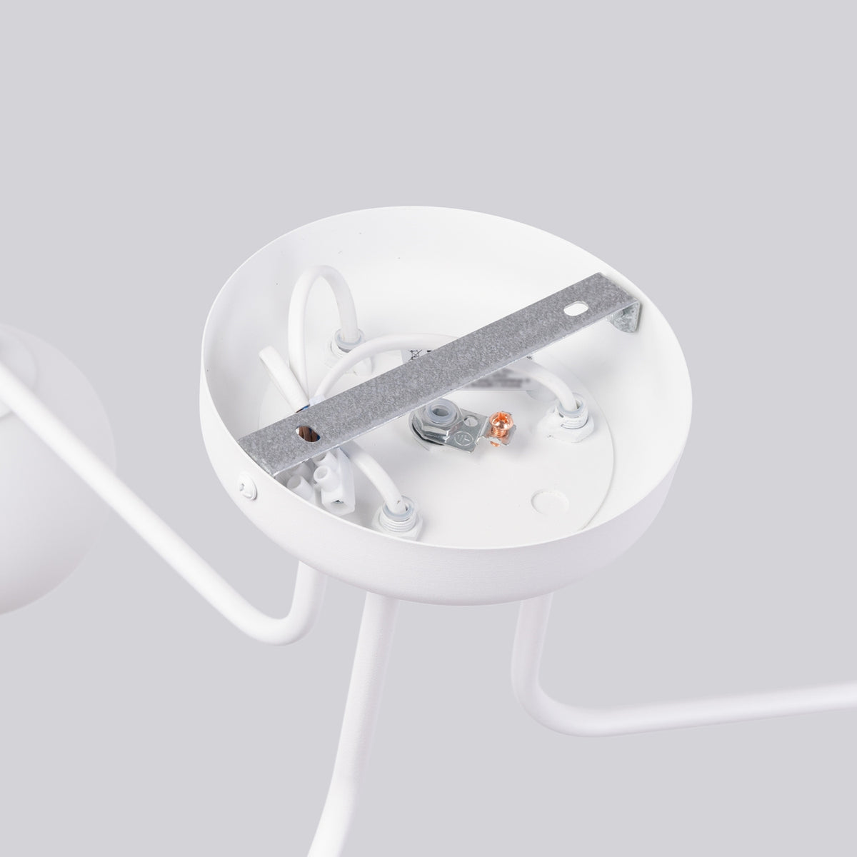 Détail du dessous de la platine : fixation métallique, câblage électrique et vis de montage.