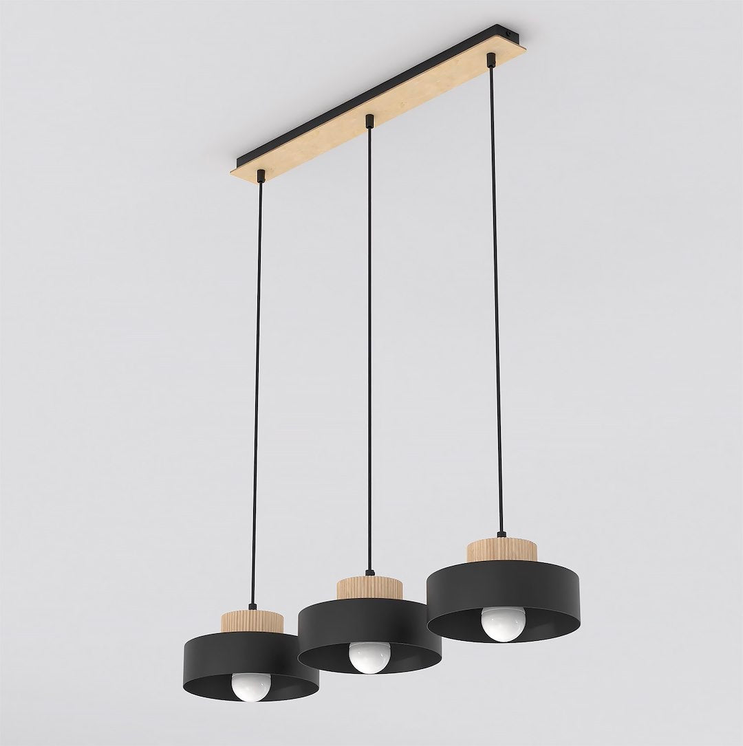 Suspension trois lumières, abat-jours cylindriques noirs et détails en bois clair, fond blanc