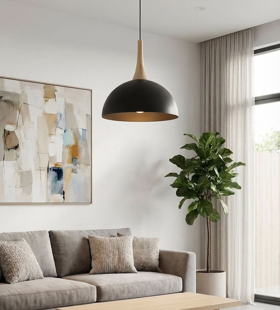 Luminaire suspendu au-dessus d'un canapé gris, près d'un grand figuier