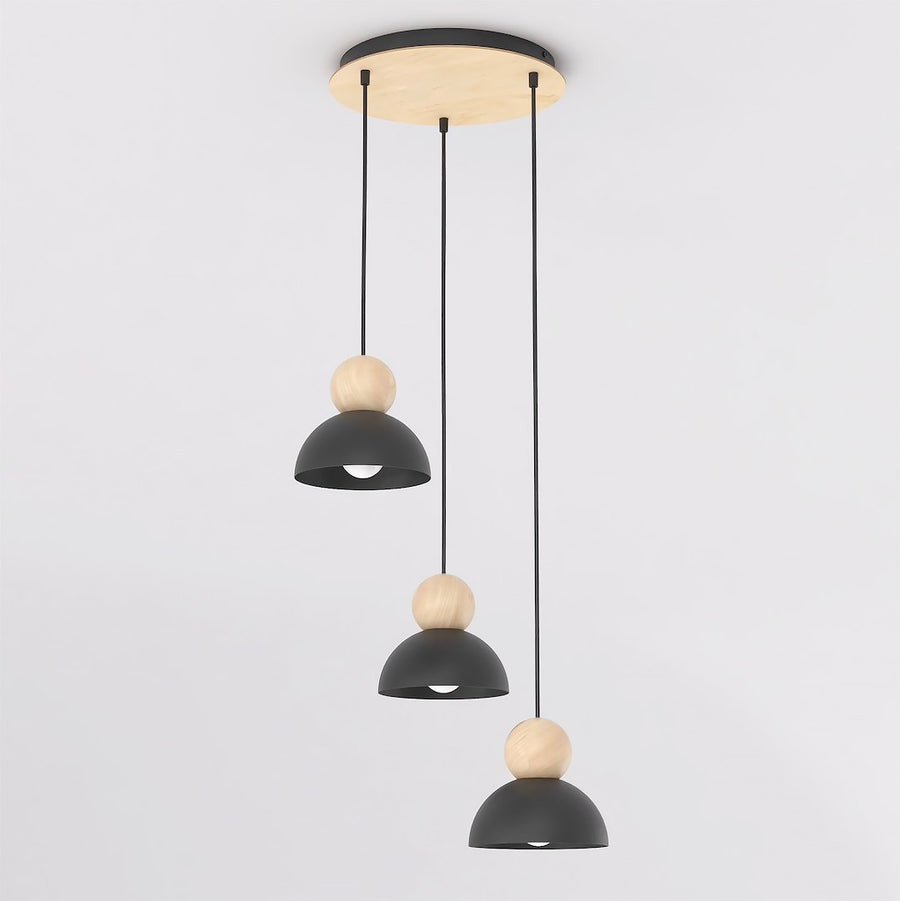 Vue de biais du luminaire, trois suspensions décalées sous une rosace ronde en bois
