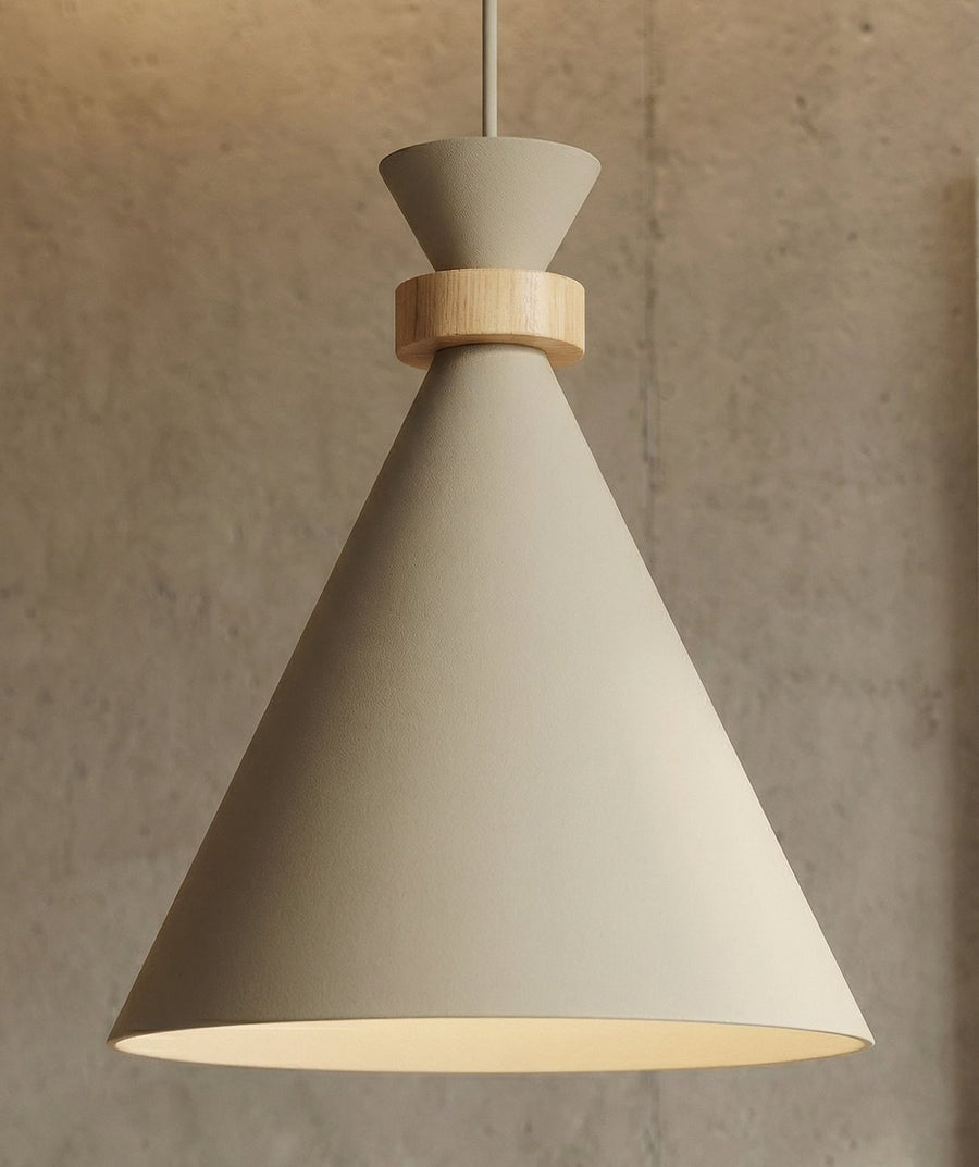 Détail rapproché d'un abat-jour conique beige et de son anneau en bois clair