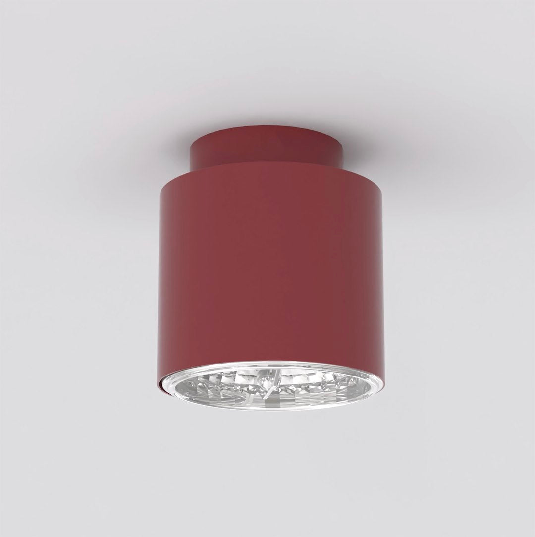 Plafonnier cylindrique bordeaux vu de face sur fond gris clair, finition mate