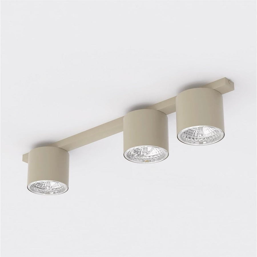 Vue de trois quarts du plafonnier beige à trois spots cylindriques orientables