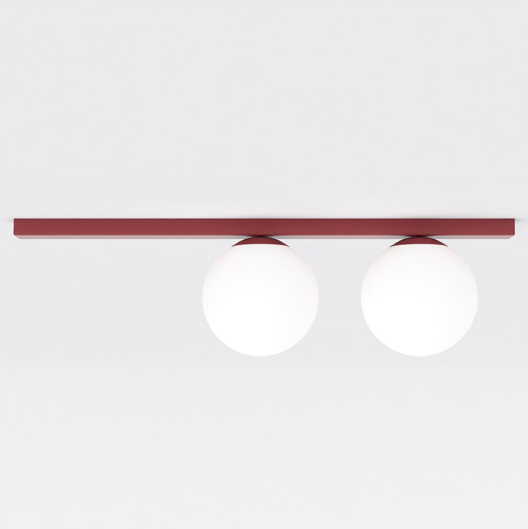 Vue de face du plafonnier à deux globes de verre blanc sur barre fine