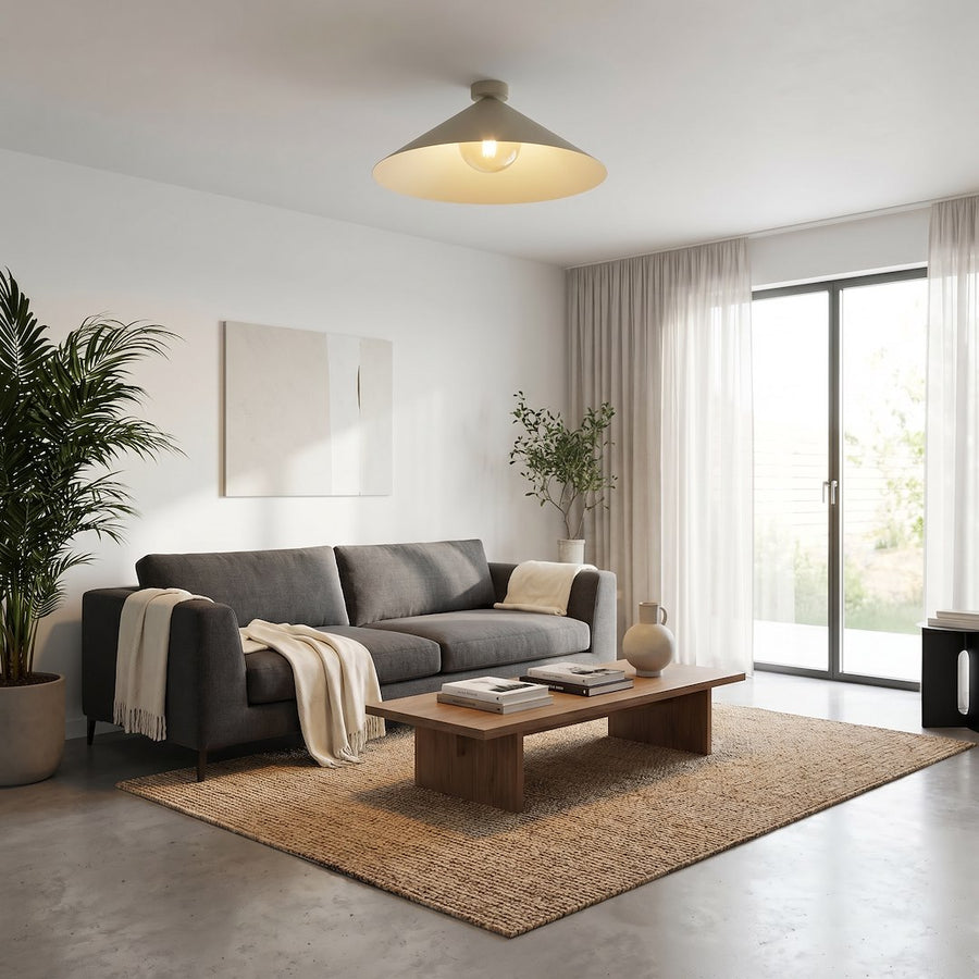 Plafonnier beige allumé au-dessus d'un salon avec canapé gris et tapis tissé