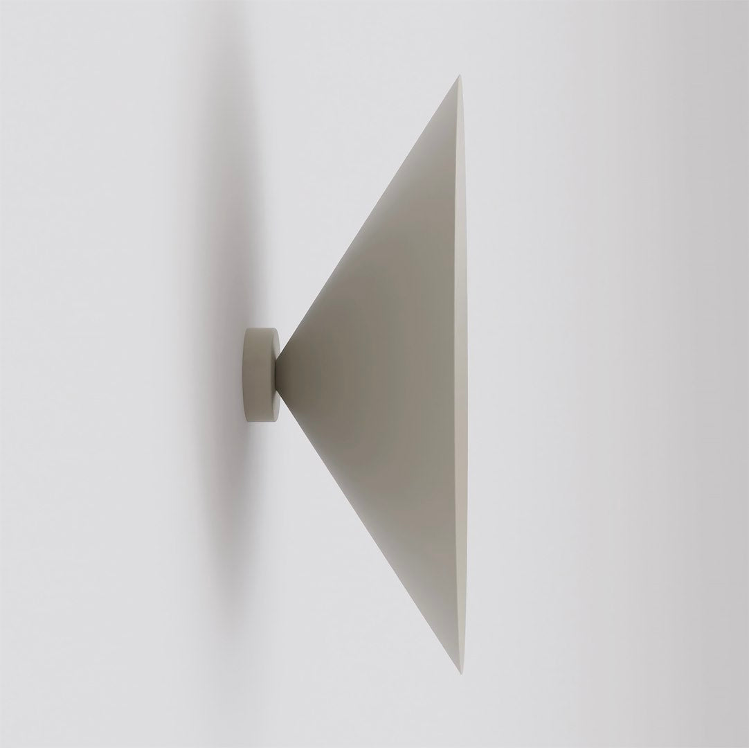 Vue de profil de l'applique murale beige à abat-jour conique orienté vers l'extérieur.