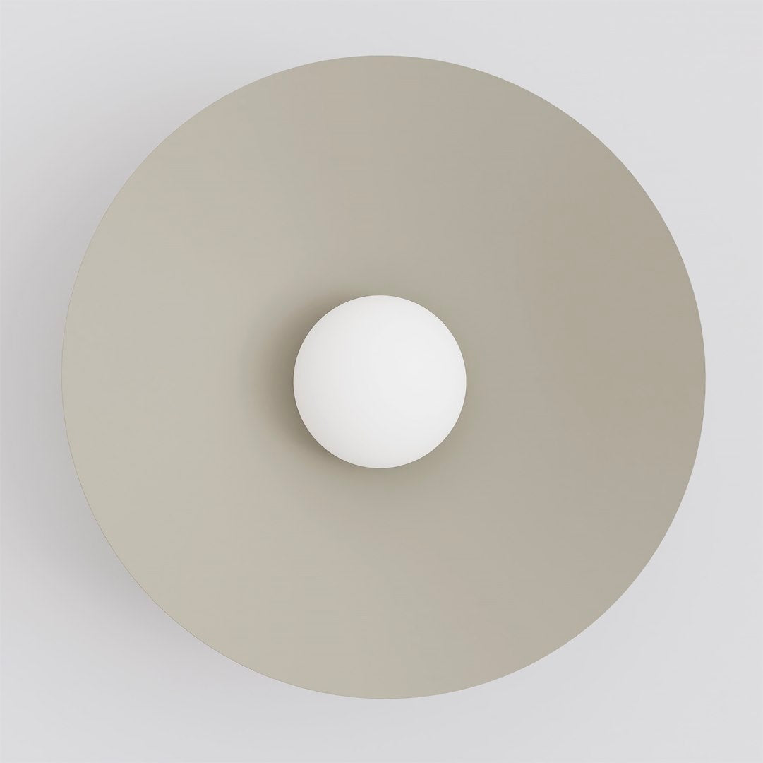 Vue de face du luminaire circulaire beige et de son globe blanc central.