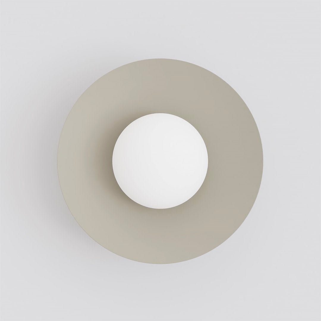 Vue de face du luminaire, grand disque beige et sphère blanche centrale.