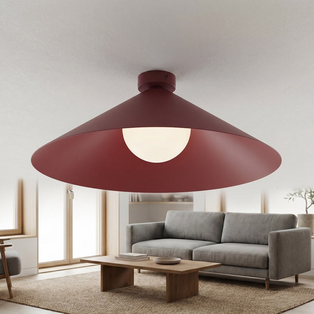 Gros plan du plafonnier bordeaux allumé, verre opalin illuminé dans un intérieur chaleureux