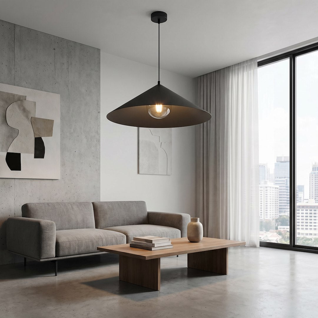 Mise en ambiance dans un salon avec canapé gris, suspension allumée au-dessus de la table basse.