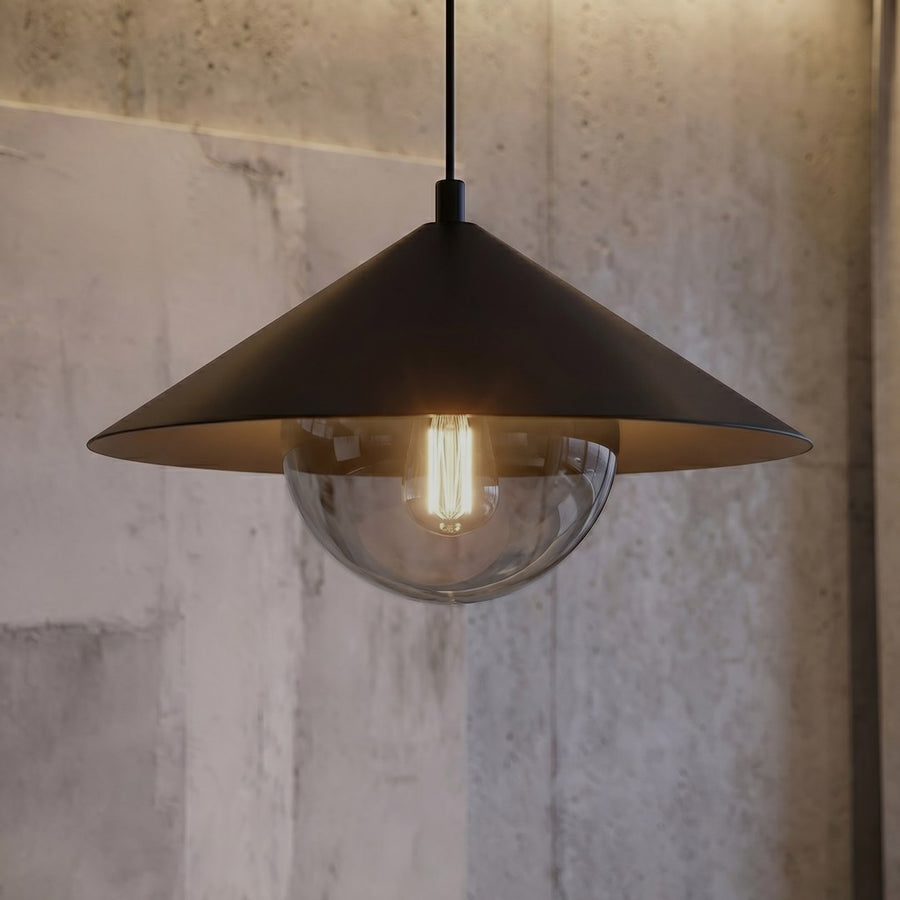 Détail de l'abat-jour noir et de la sphère en verre transparent laissant voir l'ampoule allumée.