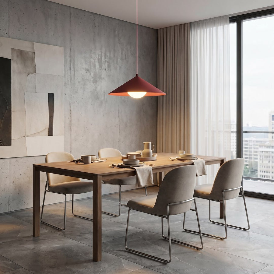 Table dressée près d'une baie vitrée, luminaire bordeaux en hauteur au-dessus des assiettes