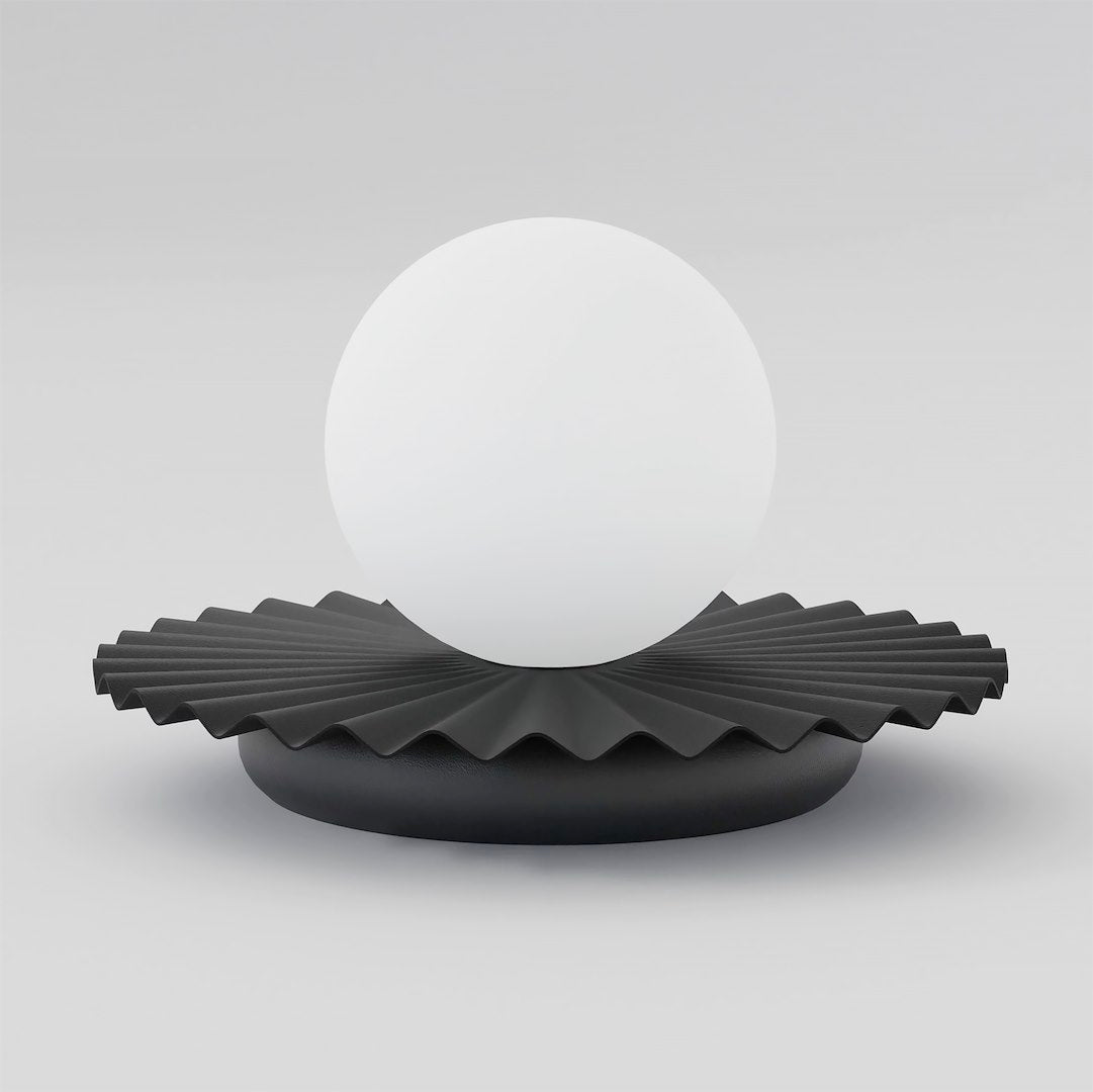 Lampe à poser vue de face, sphère de verre blanc sur socle plissé noir