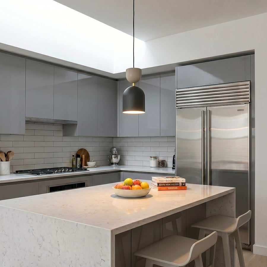 Au-dessus d'un îlot de cuisine, le luminaire éclaire le plan de travail en marbre.