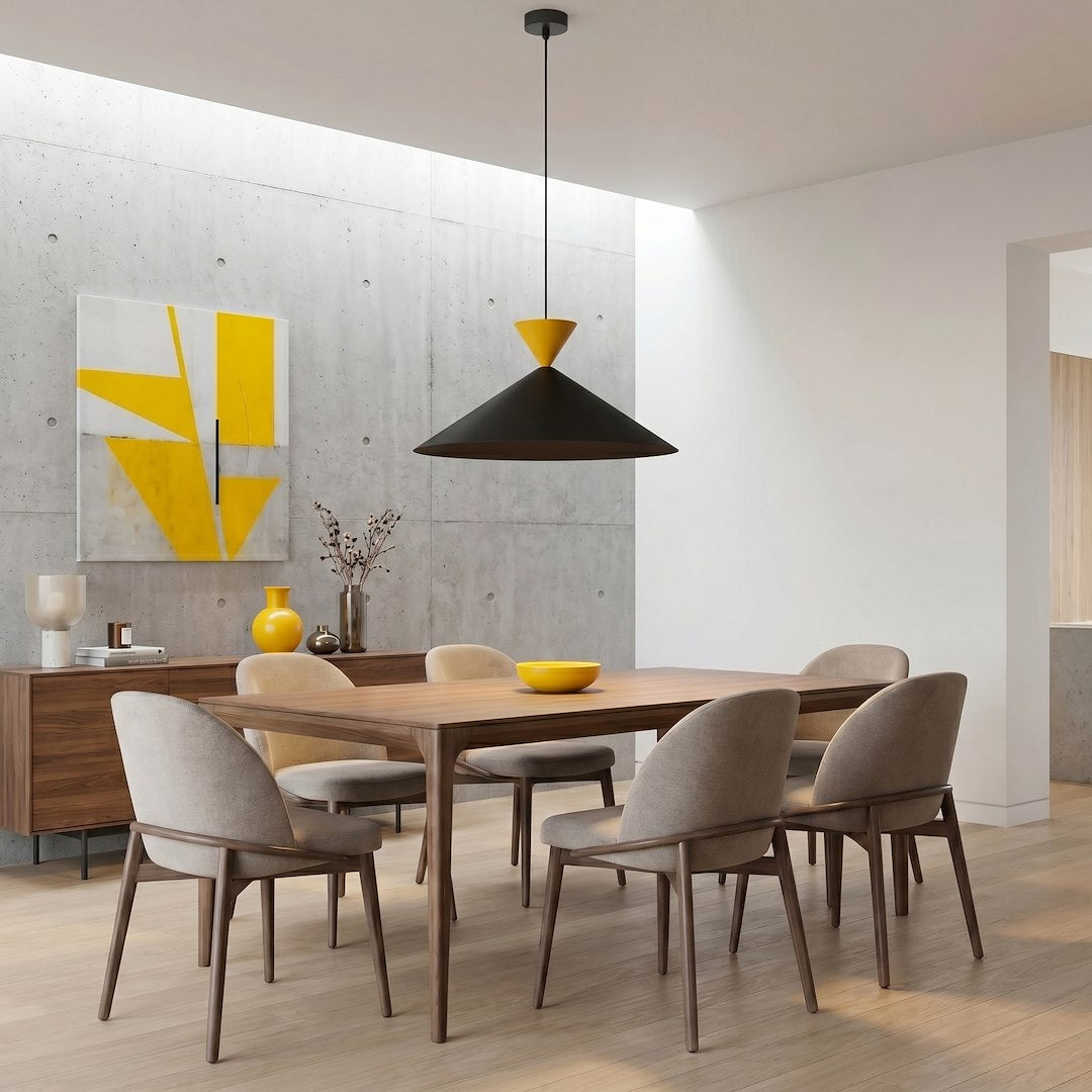 Mise en scène dans une salle à manger, suspension conique noire et jaune au-dessus de la table.
