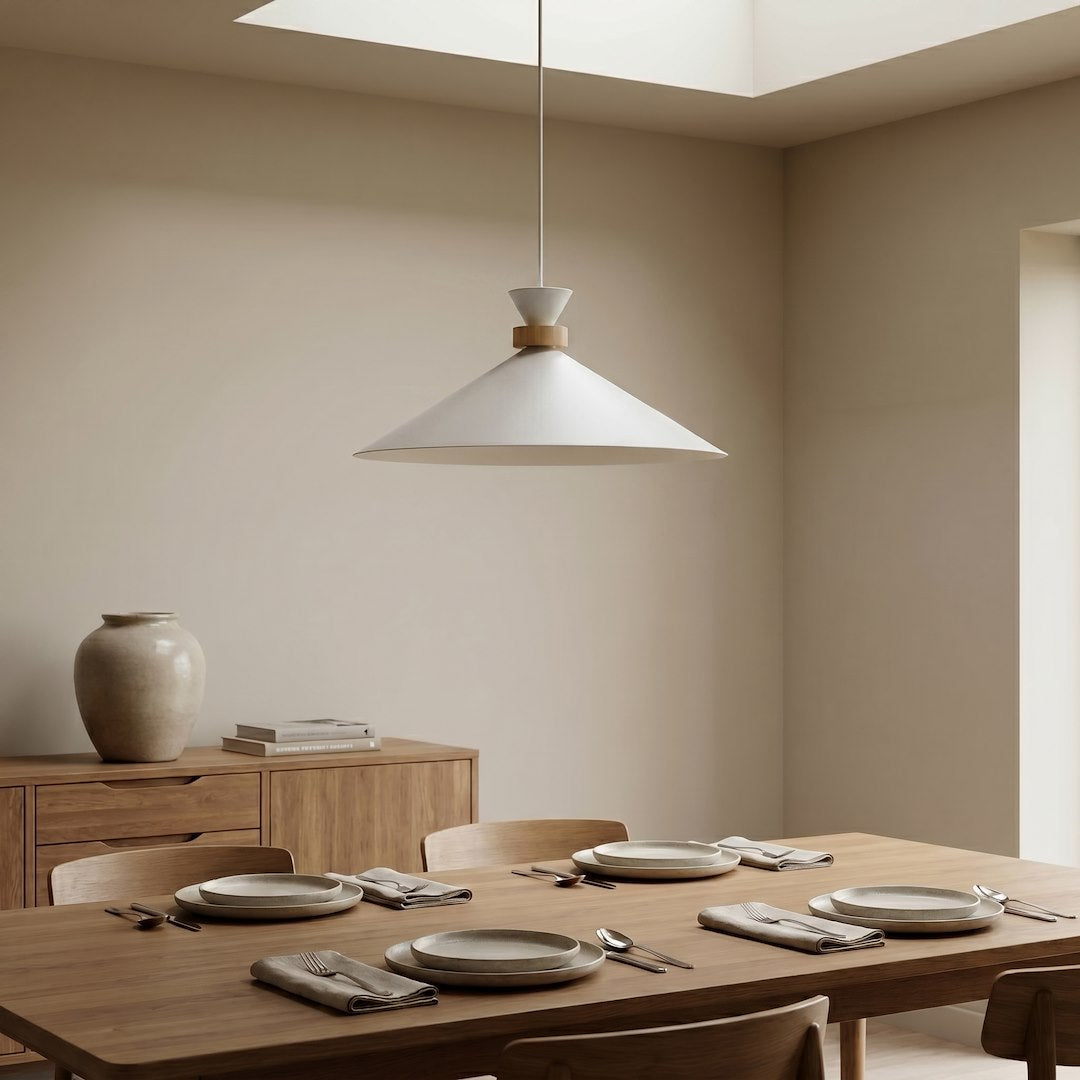 Mise en ambiance dans une salle à manger, suspension blanche éclairant une table en bois.