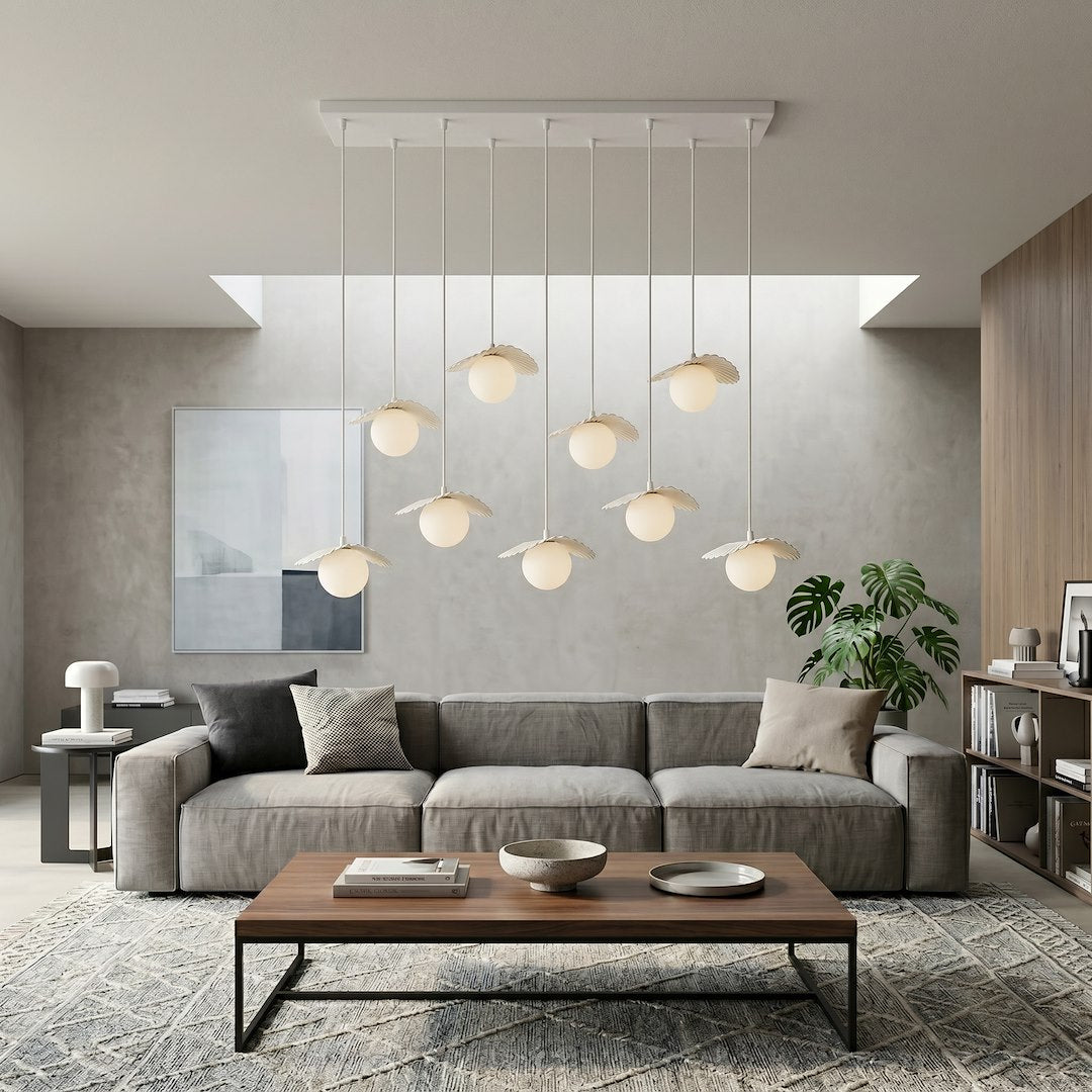 Mise en ambiance dans un salon : suspension allumée au-dessus d'un canapé et table basse