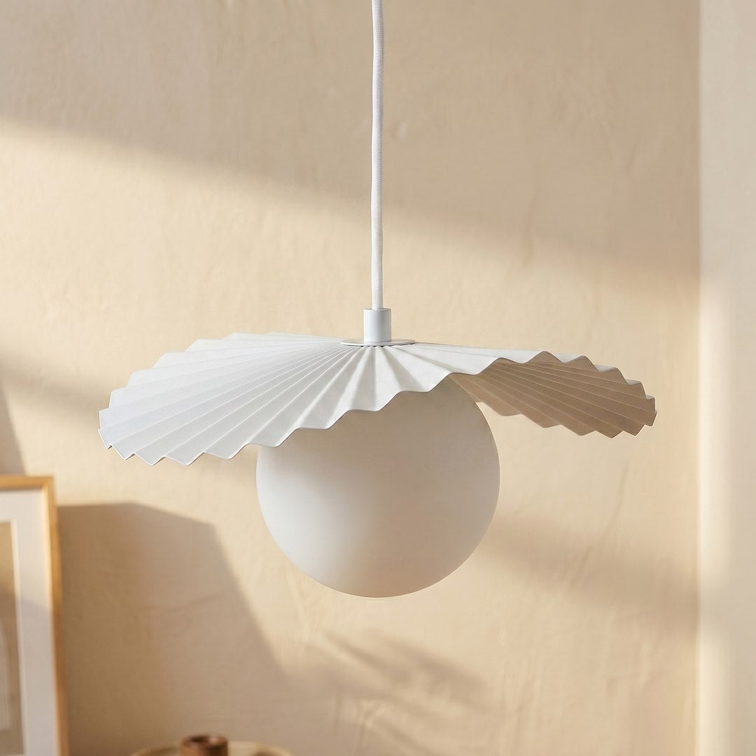 Détail rapproché d'une sphère en verre blanc et de sa collerette plissée façon origami