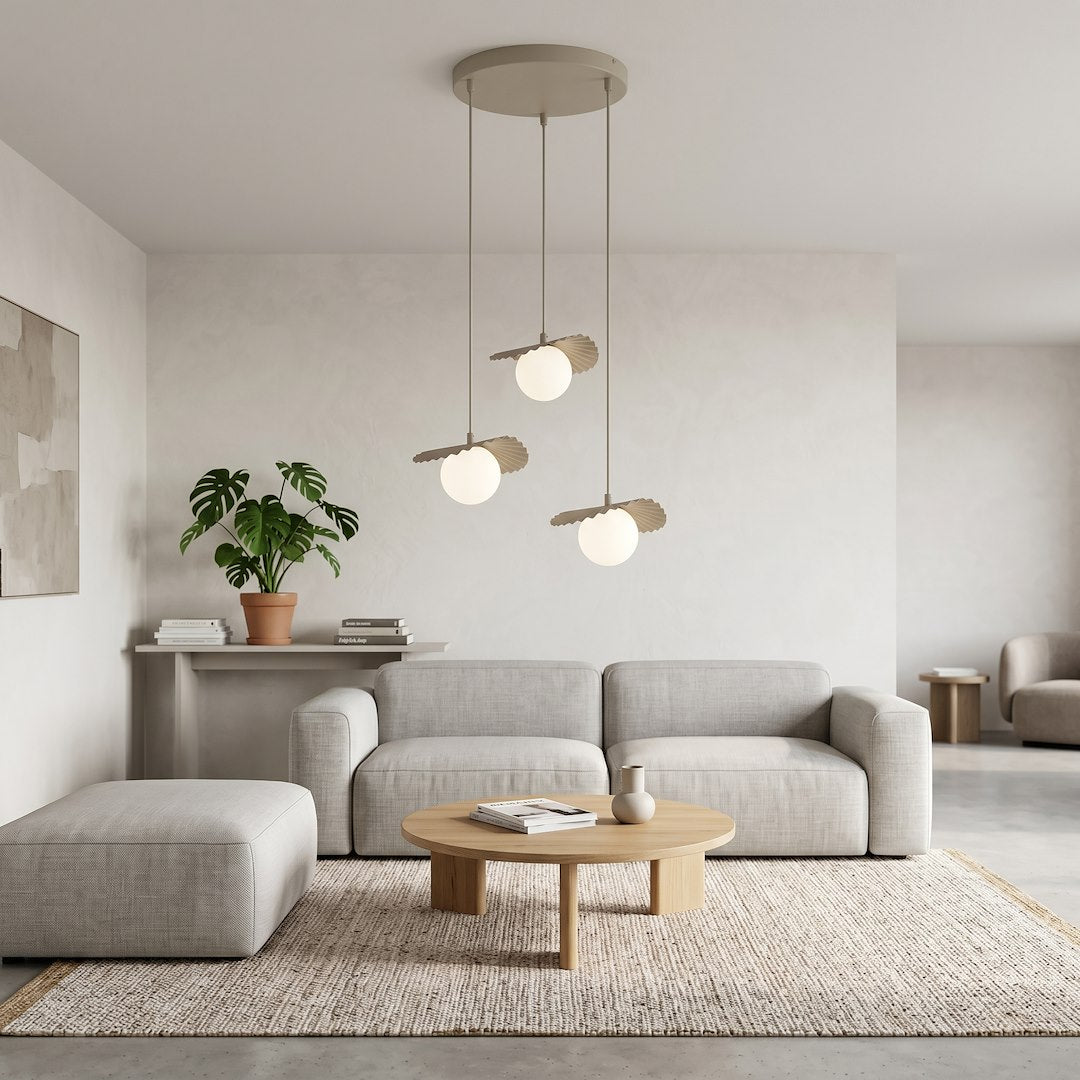 Scène de salon clair avec canapé gris, table basse et suspension allumée.