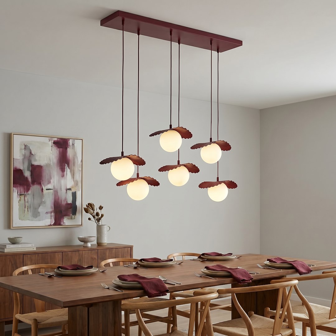 Salle à manger bois avec suspension six lumières bordeaux au-dessus de la table dressée