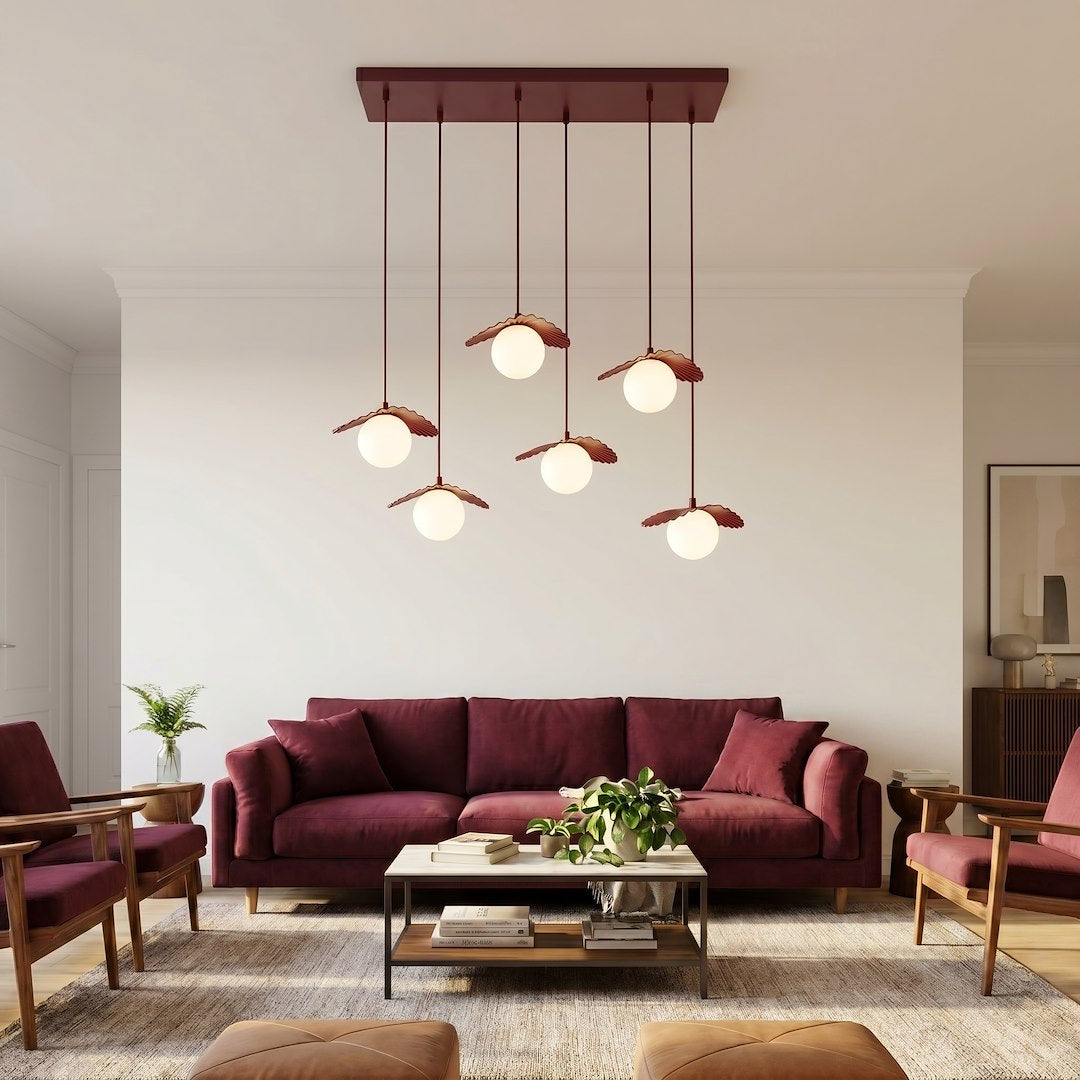 Ambiance salon bordeaux, canapé assorti et suspension fleur suspendue au plafond blanc