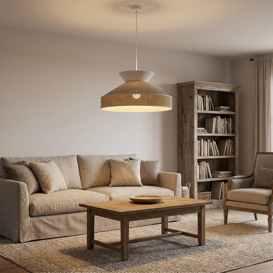 Intérieur campagne chaleureux, canapé beige et bibliothèque bois sous la suspension allumée