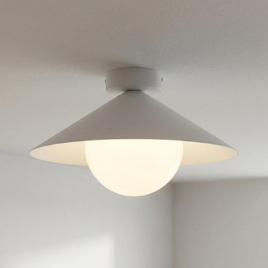 Detail du luminaire allume, halo lumineux chaud traversant le verre depoli