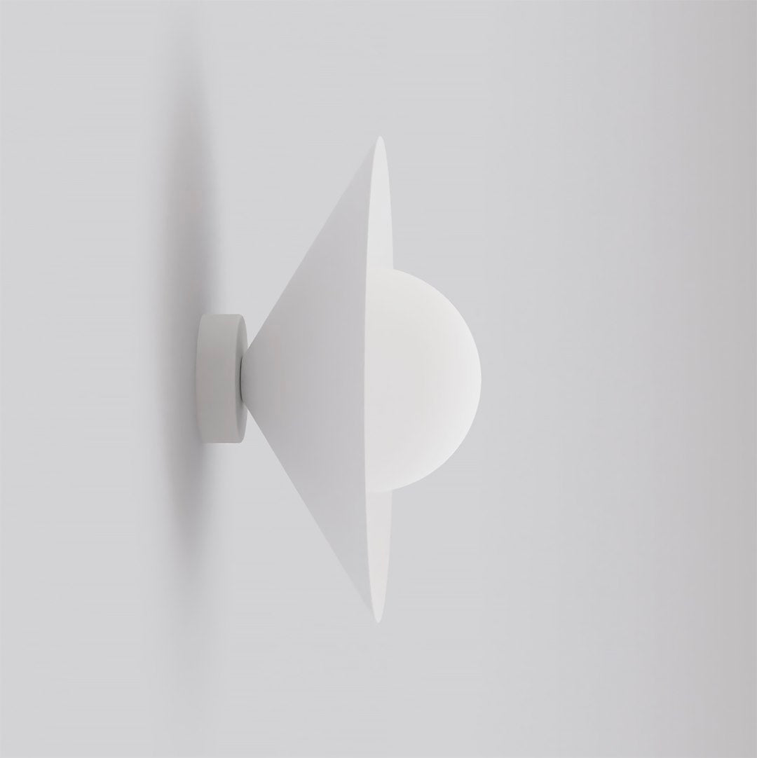 Vue de profil du luminaire blanc sur fond neutre, cône et sphère empilés