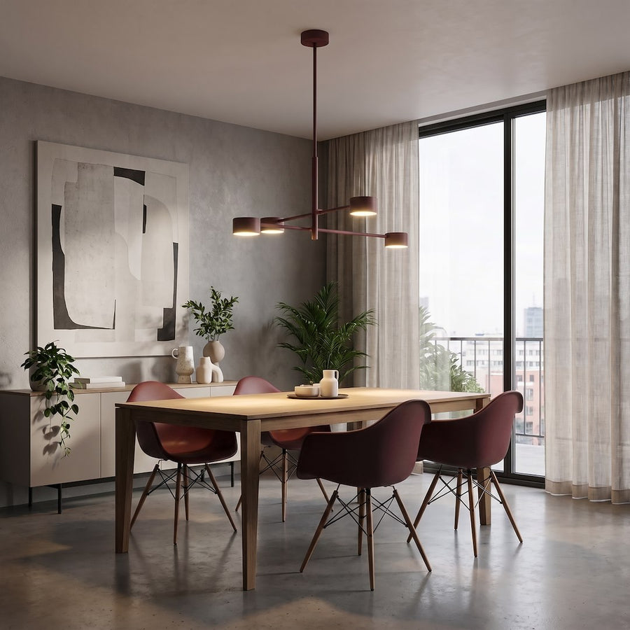 Mise en ambiance salle à manger en bois avec chaises bordeaux et grand luminaire