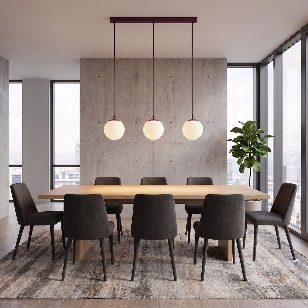 Mise en ambiance au-dessus d'une table à manger en bois, murs béton et grandes fenêtres.