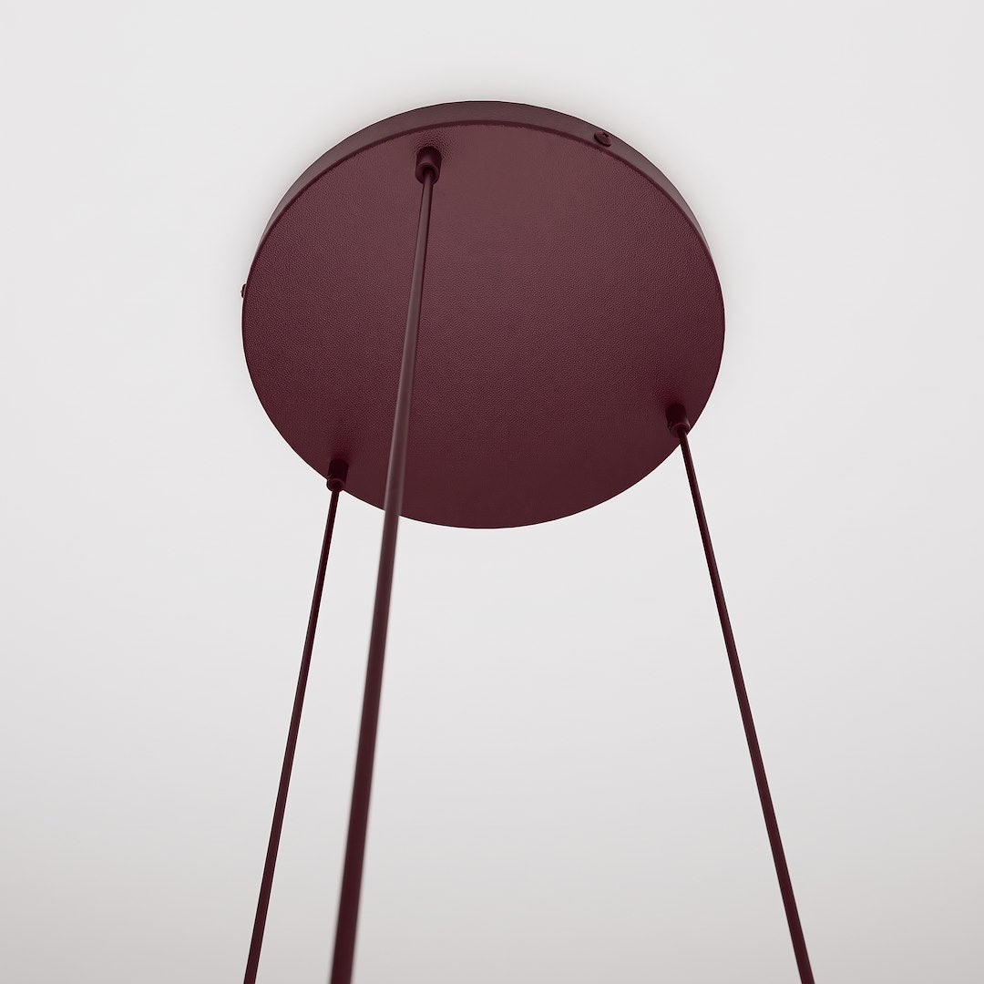 Détail de la rosace ronde bordeaux vue de dessous, trois câbles fins tendus vers les globes.