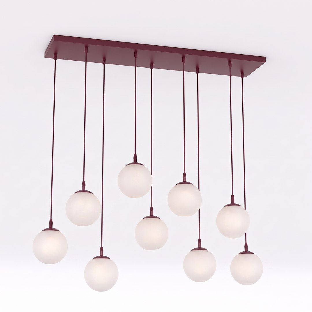 Suspension à neuf globes de verre blanc opalin sur platine rectangulaire bordeaux, fond neutre