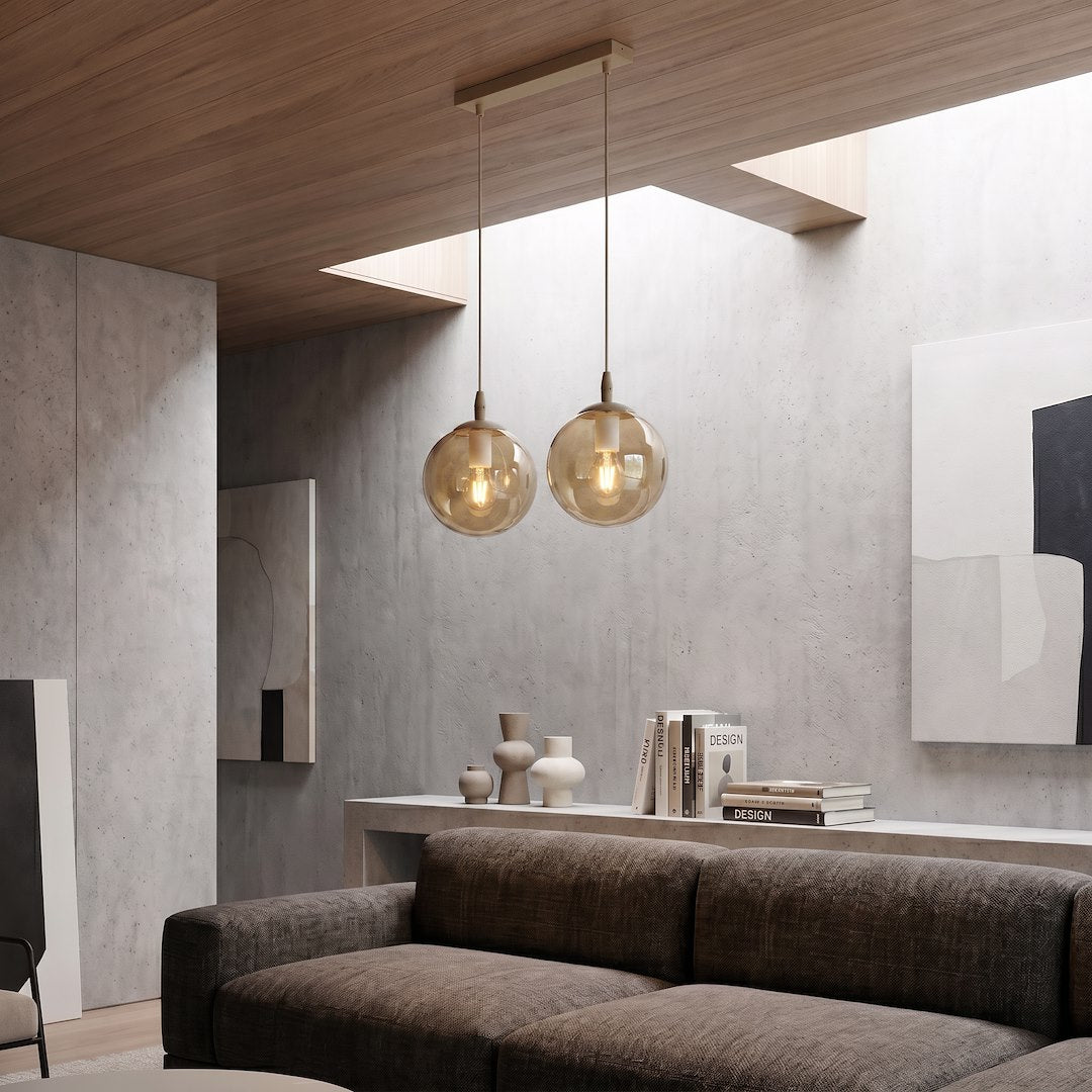 Mise en ambiance du luminaire suspendu dans un séjour béton avec canapé et objets déco.