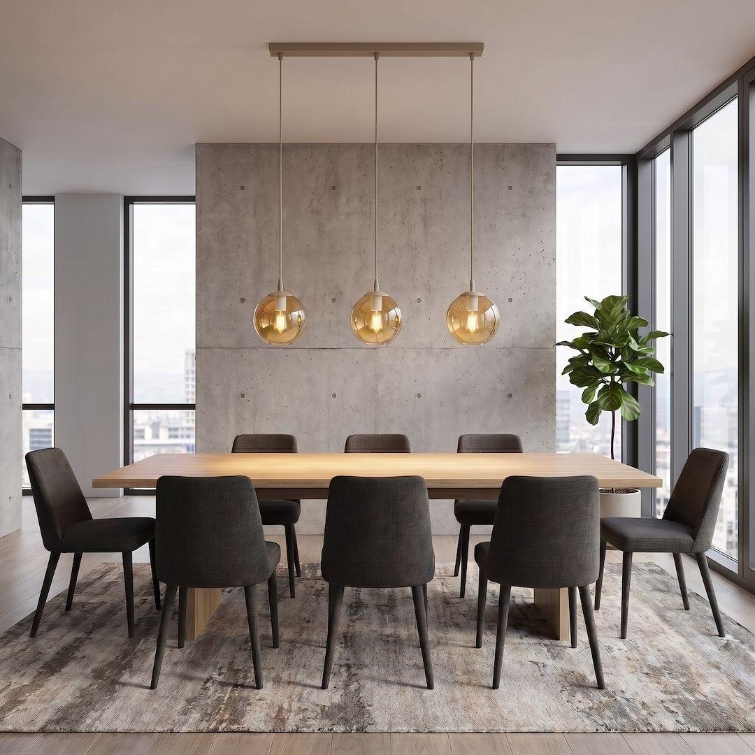 Mise en ambiance au-dessus d'une table de salle à manger en béton, avec trois suspensions alignées.