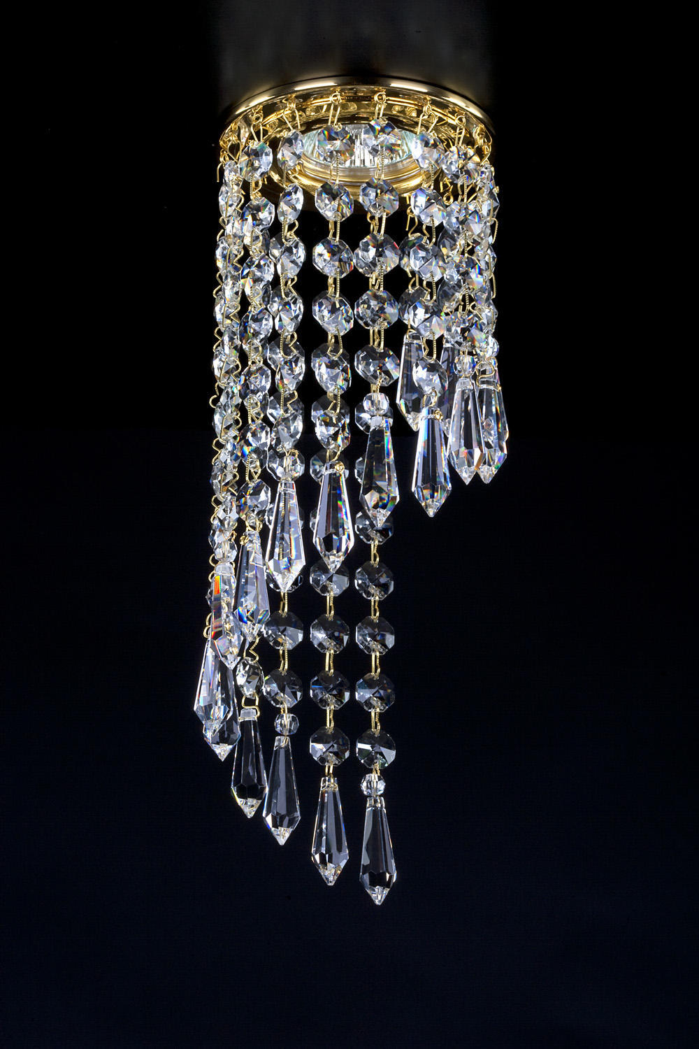 Luminaire doré avec cascade de cristaux taillés suspendus, vu de face sur fond noir.
