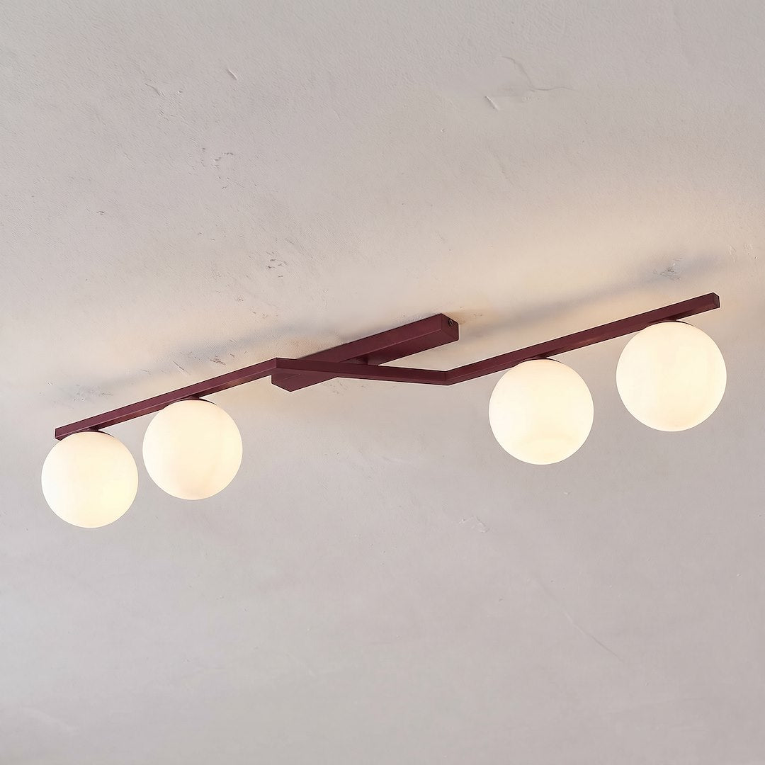 Vue de dessous du luminaire fixé au plafond, quatre globes allumés alignés
