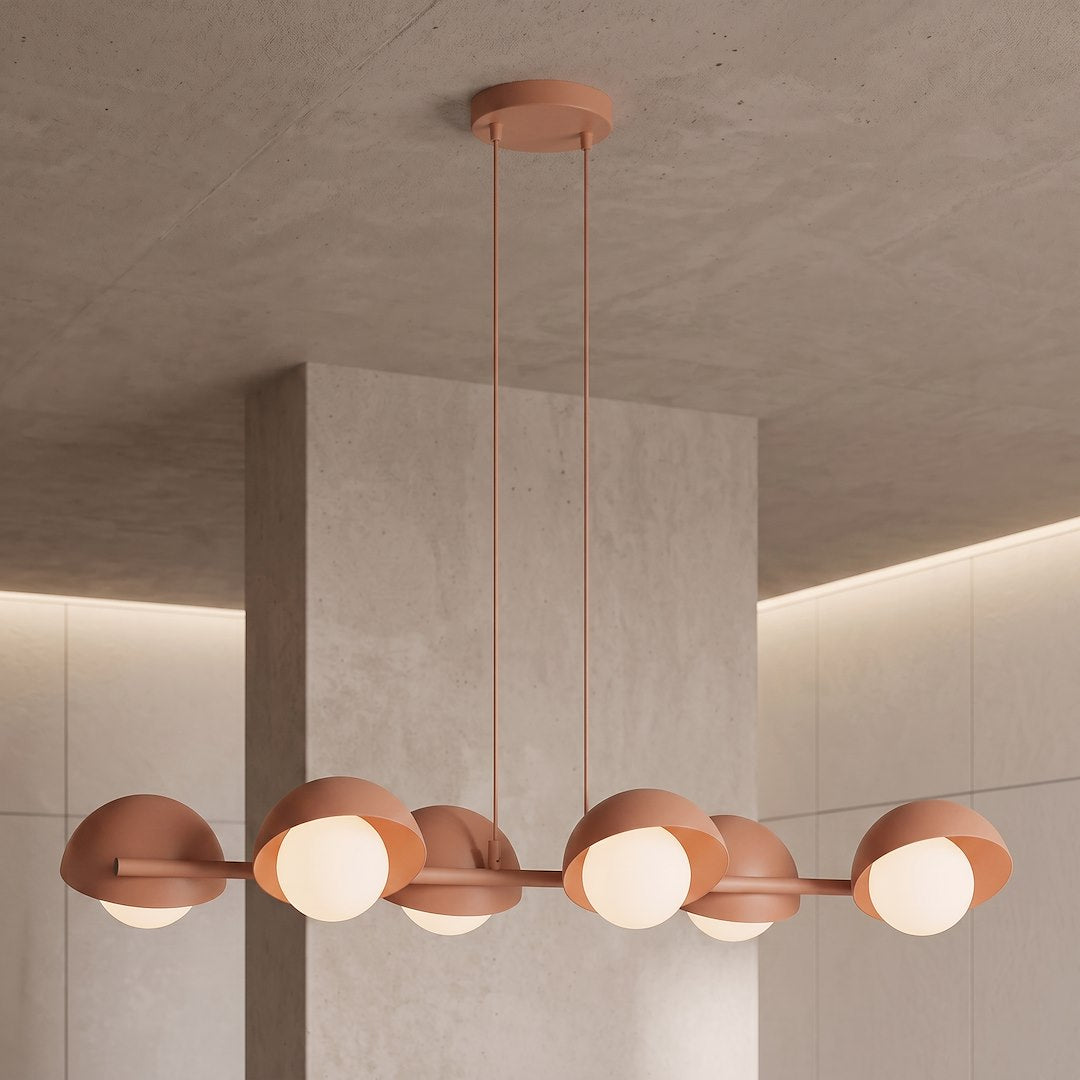 Luminaire suspendu au plafond en béton, mettant en valeur ses abat-jours corail.