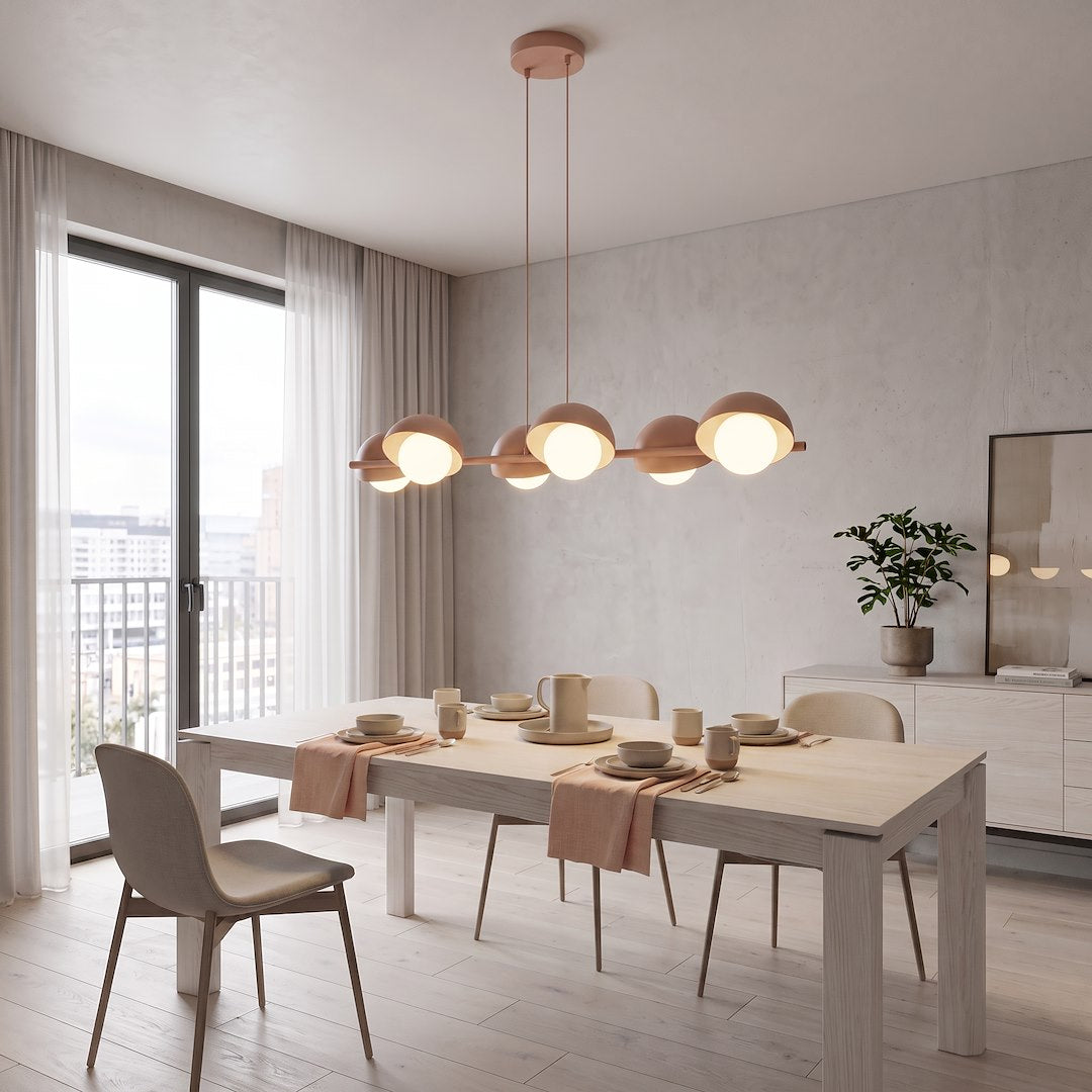 Mise en ambiance du luminaire au-dessus d'une table dressée dans une salle à manger lumineuse.