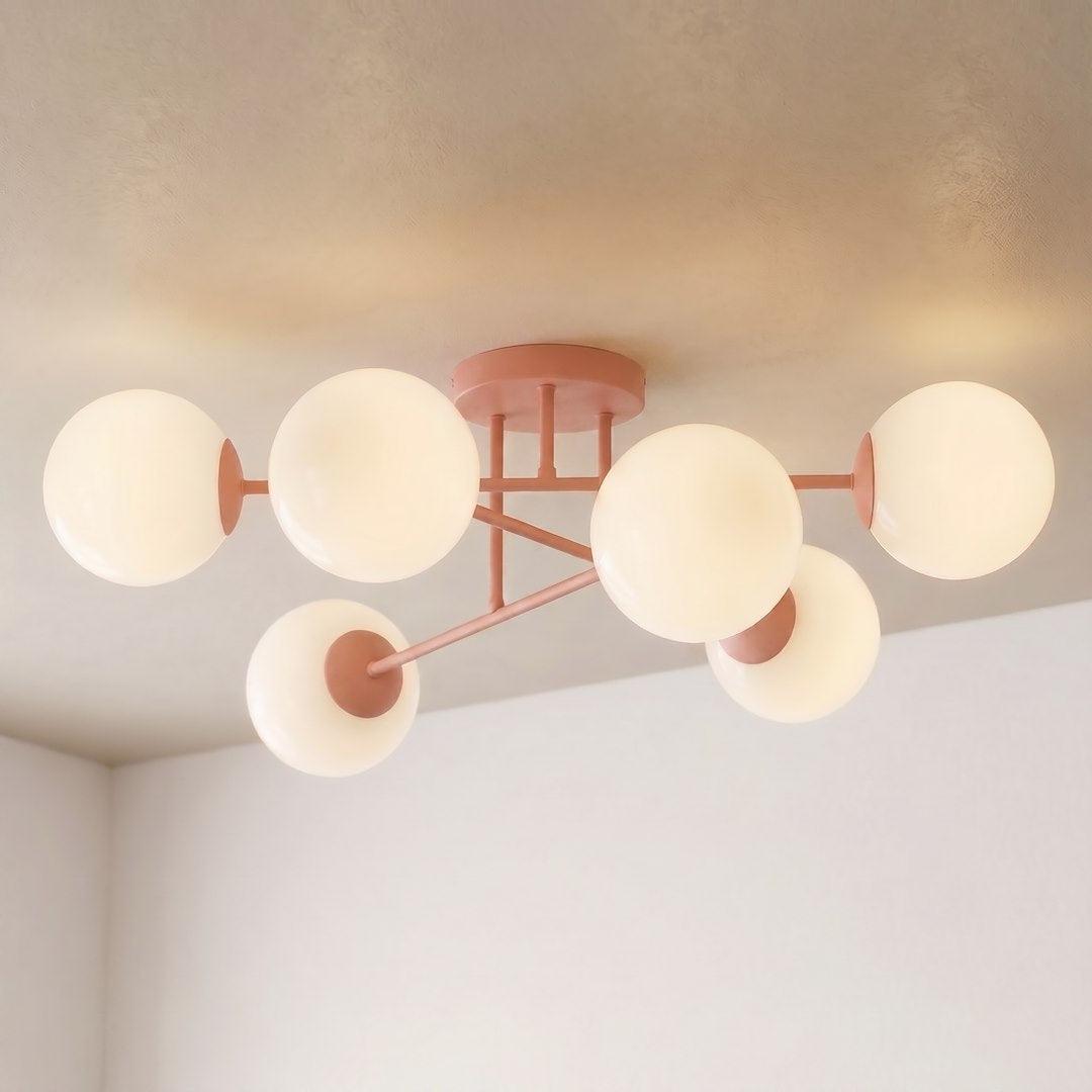 Vue en contre-plongée du luminaire allumé, six sphères ivoire rayonnant sous un plafond beige.