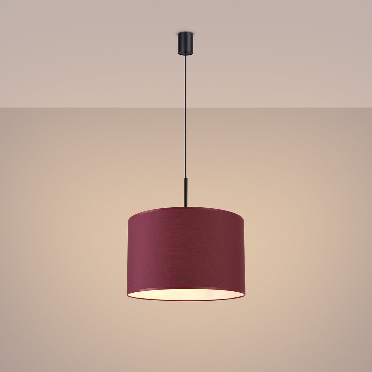 Ambiance tamisée, luminaire allumé diffusant une lumière chaude sur le mur beige