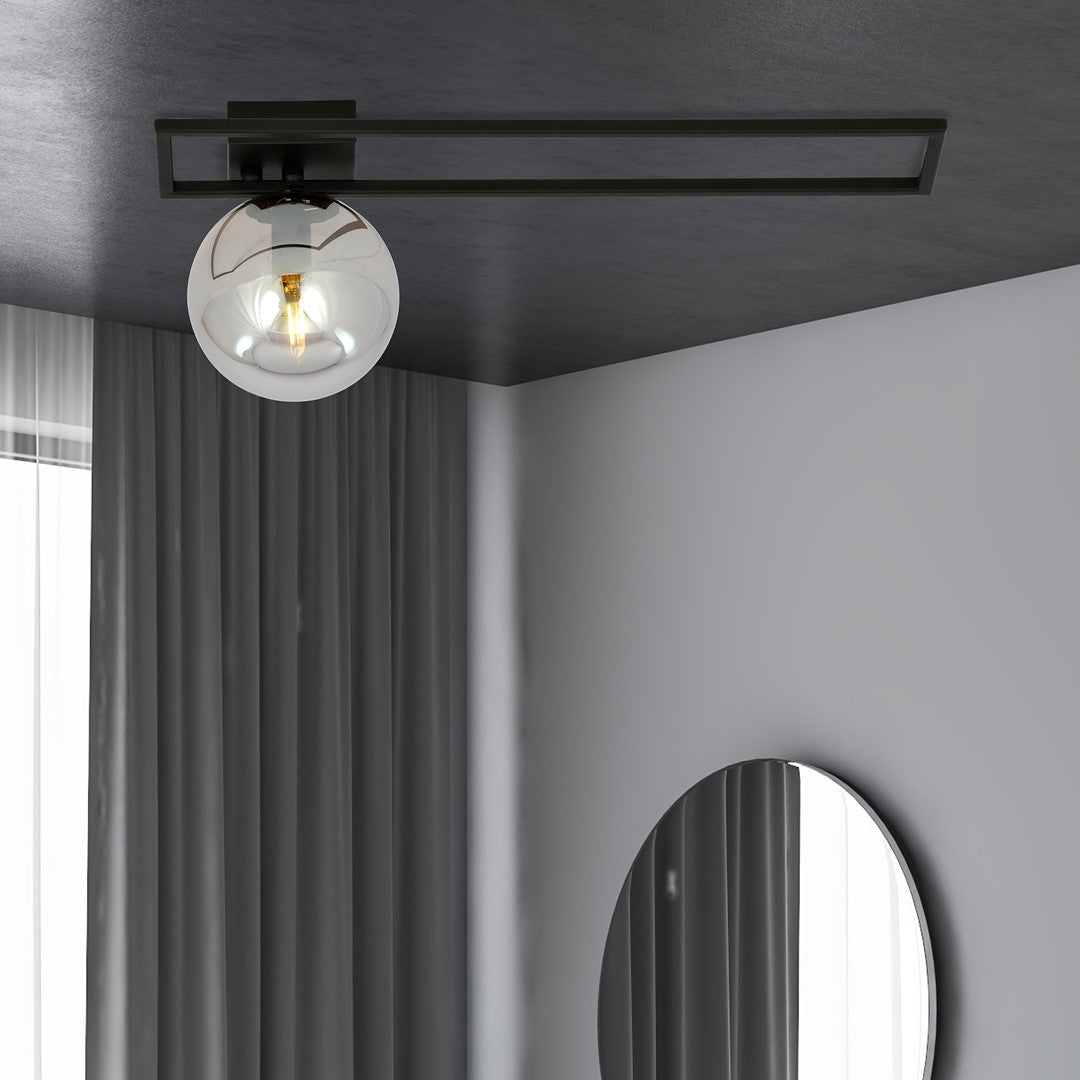 Mise en ambiance sombre, plafonnier allumé au-dessus d'un miroir rond