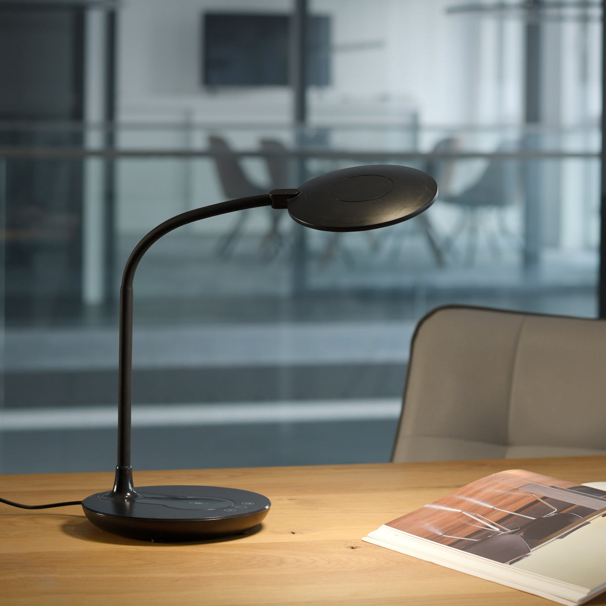 Mise en ambiance sur un bureau en bois avec magazine ouvert