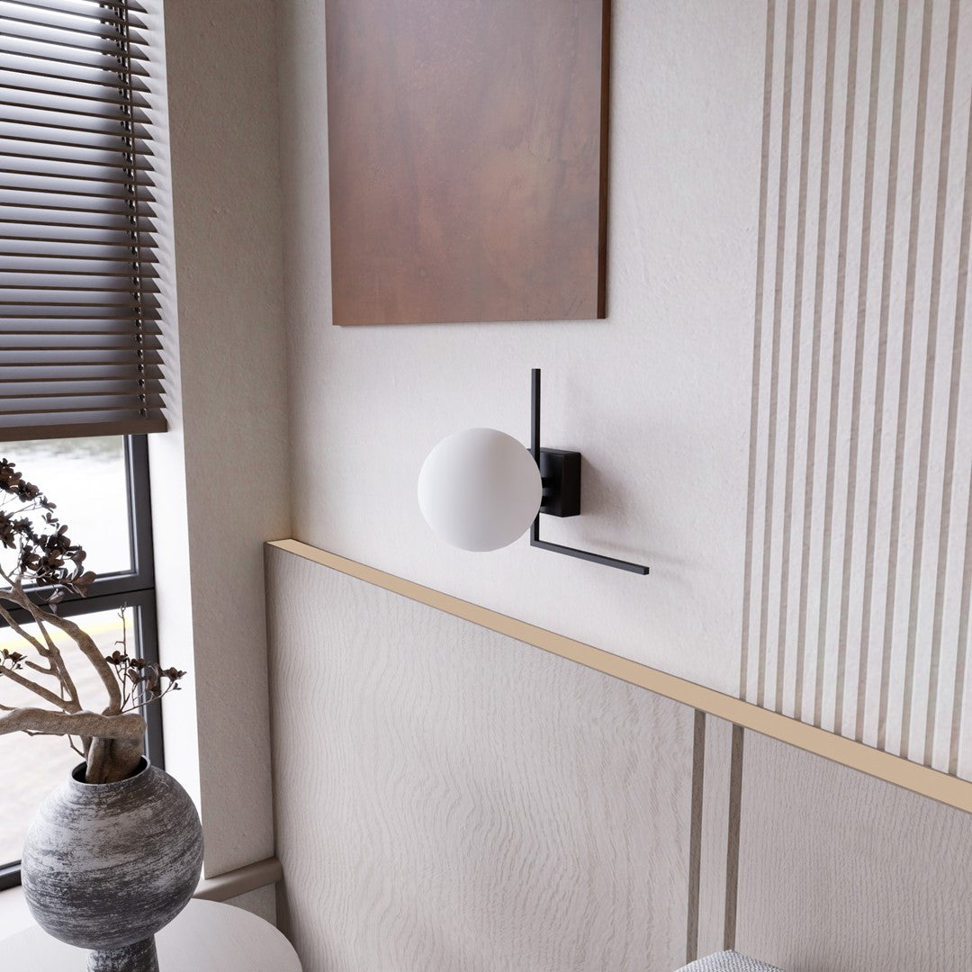 Applique éteinte sur fond crème, détail du bras métallique et du verre