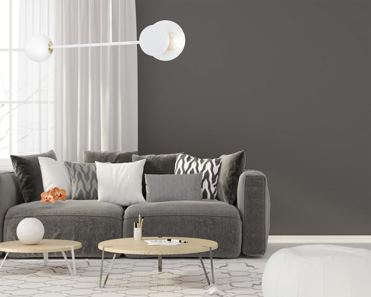 Plafonnier blanc allumé au-dessus d'un canapé gris avec coussins décoratifs