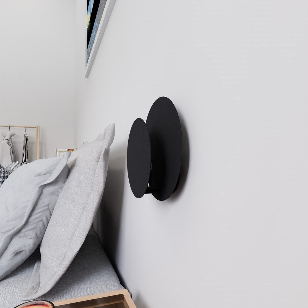 Applique murale éteinte vue de trois quarts dans une chambre au mur clair