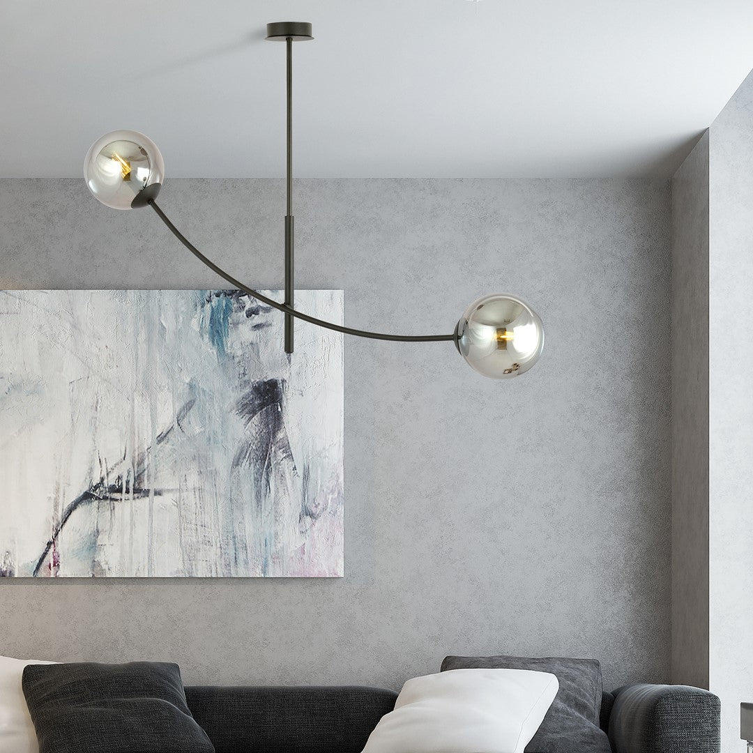 Mise en ambiance du luminaire allumé au-dessus d'un canapé gris dans un salon.
