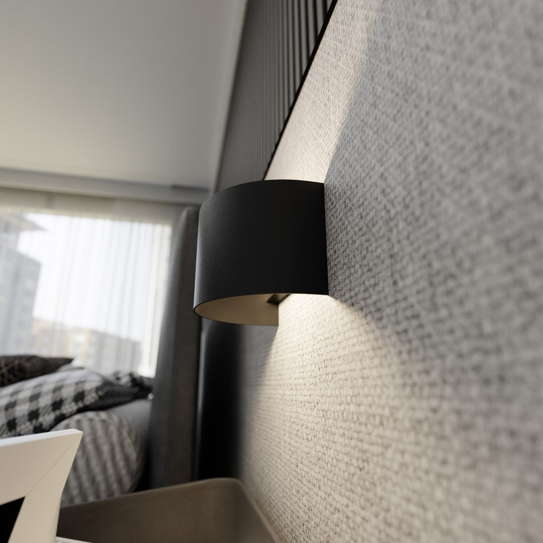 Détail en contre-plongée montrant le cylindre noir et son ombre portée sur le mur