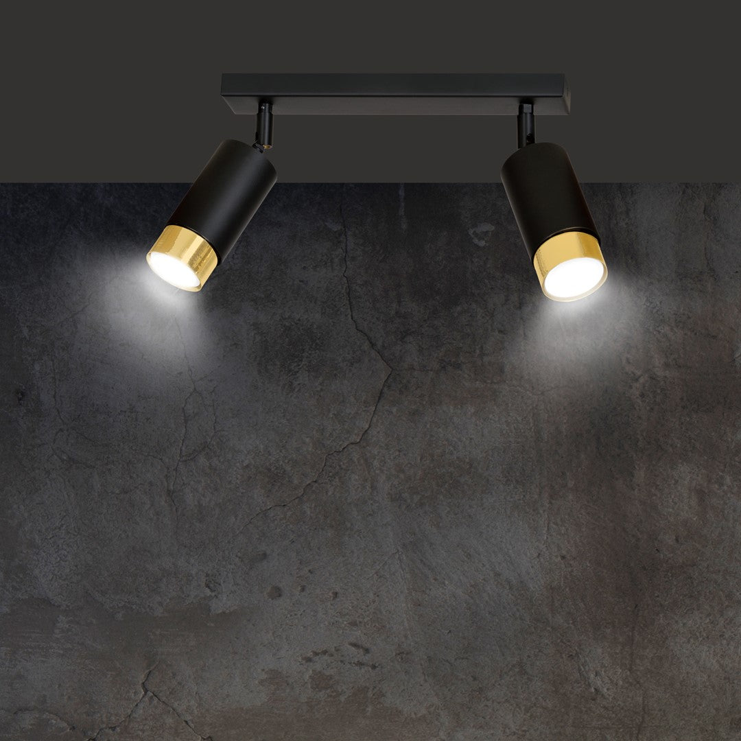 Détail du luminaire sur mur gris effet béton fissuré avec halos lumineux